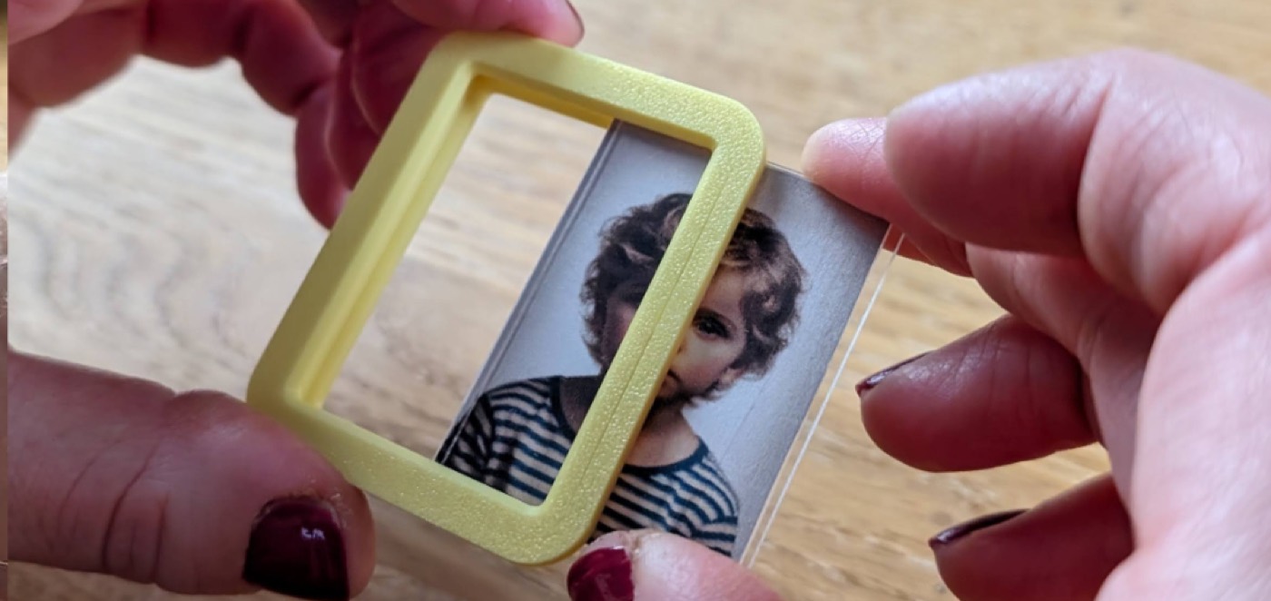 Passfoto zwischen zwei Plexiglas-Scheiben in den Rahmen schieben
